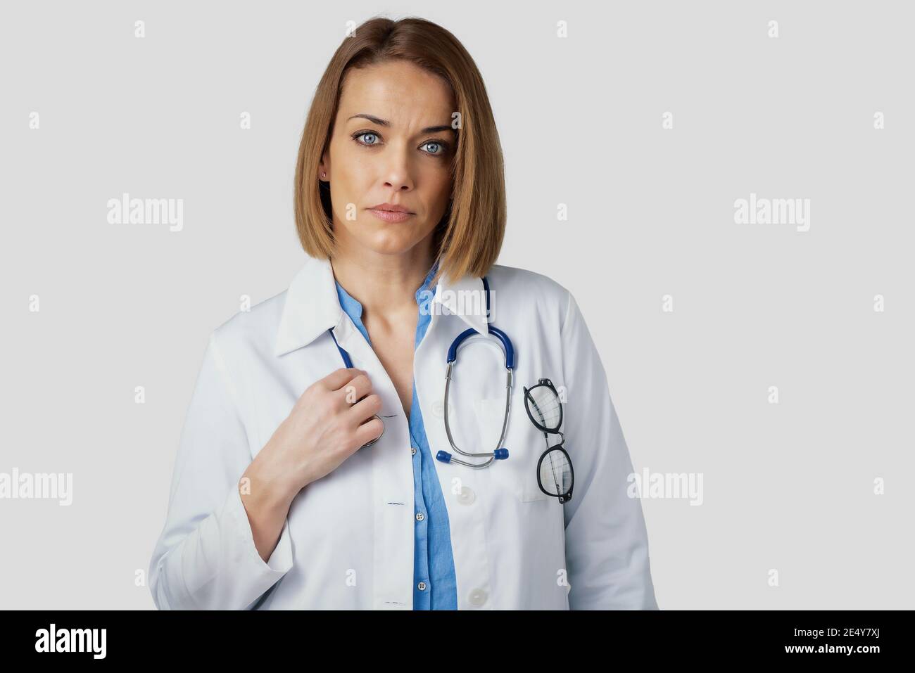 Close-up Studio Porträt von mittleren Alters weibliche Ärztin, die auf isolierten weißen Hintergrund. Speicherplatz kopieren. Stockfoto