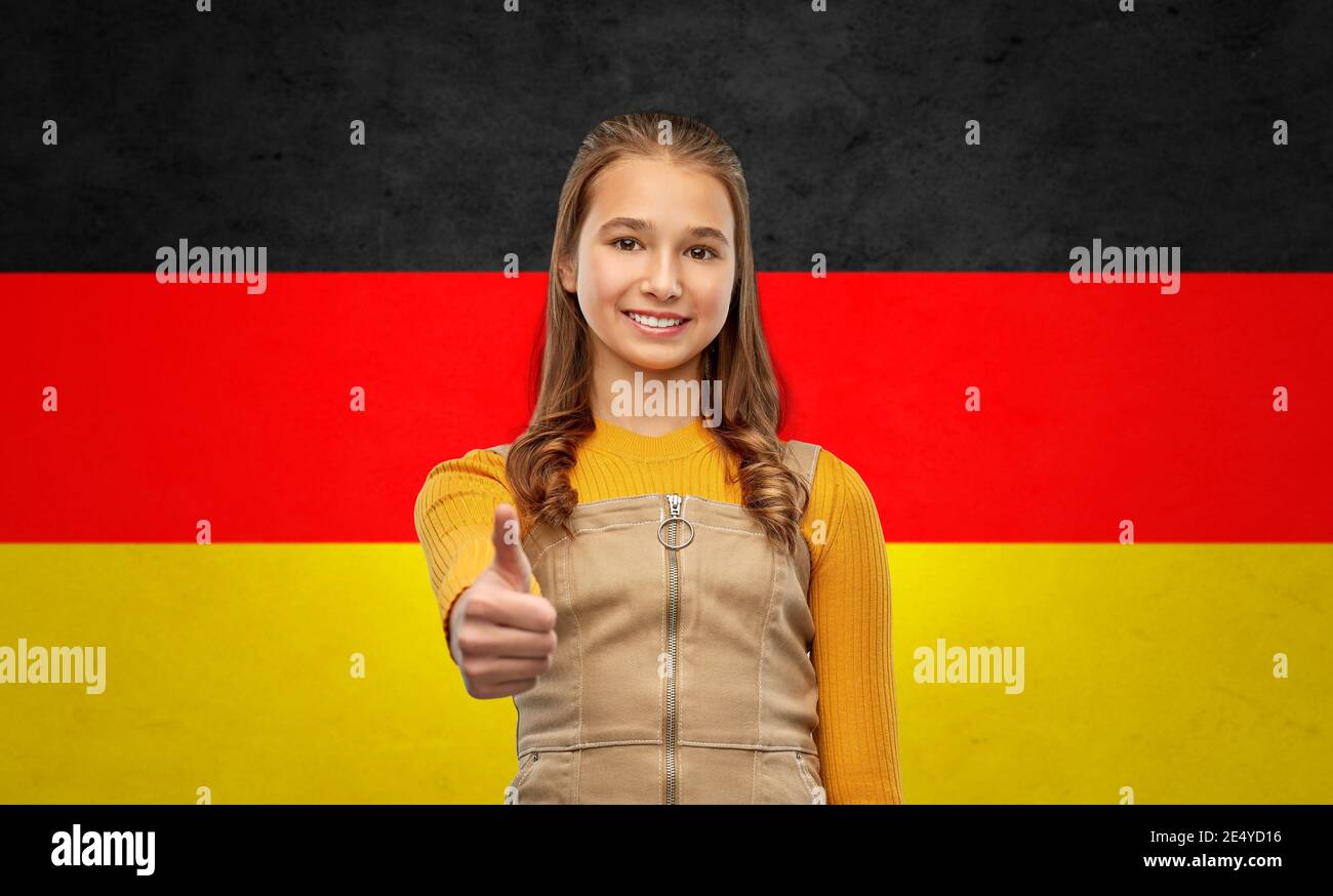 Teenager Mädchen zeigt Daumen nach oben über deutsche Flagge Stockfoto