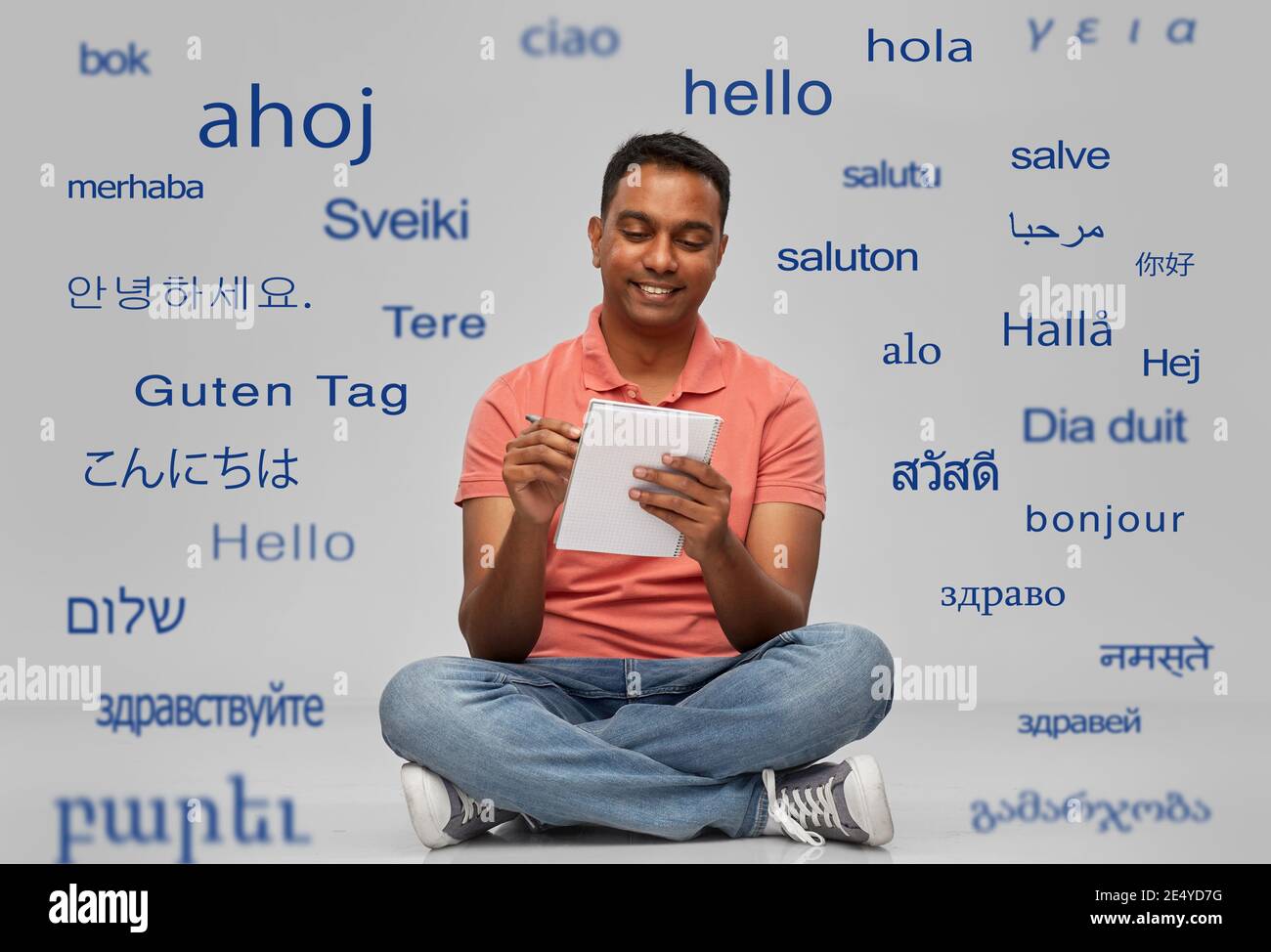 indischer Mann im Poloshirt Schreiben auf Notizbuch Stockfoto