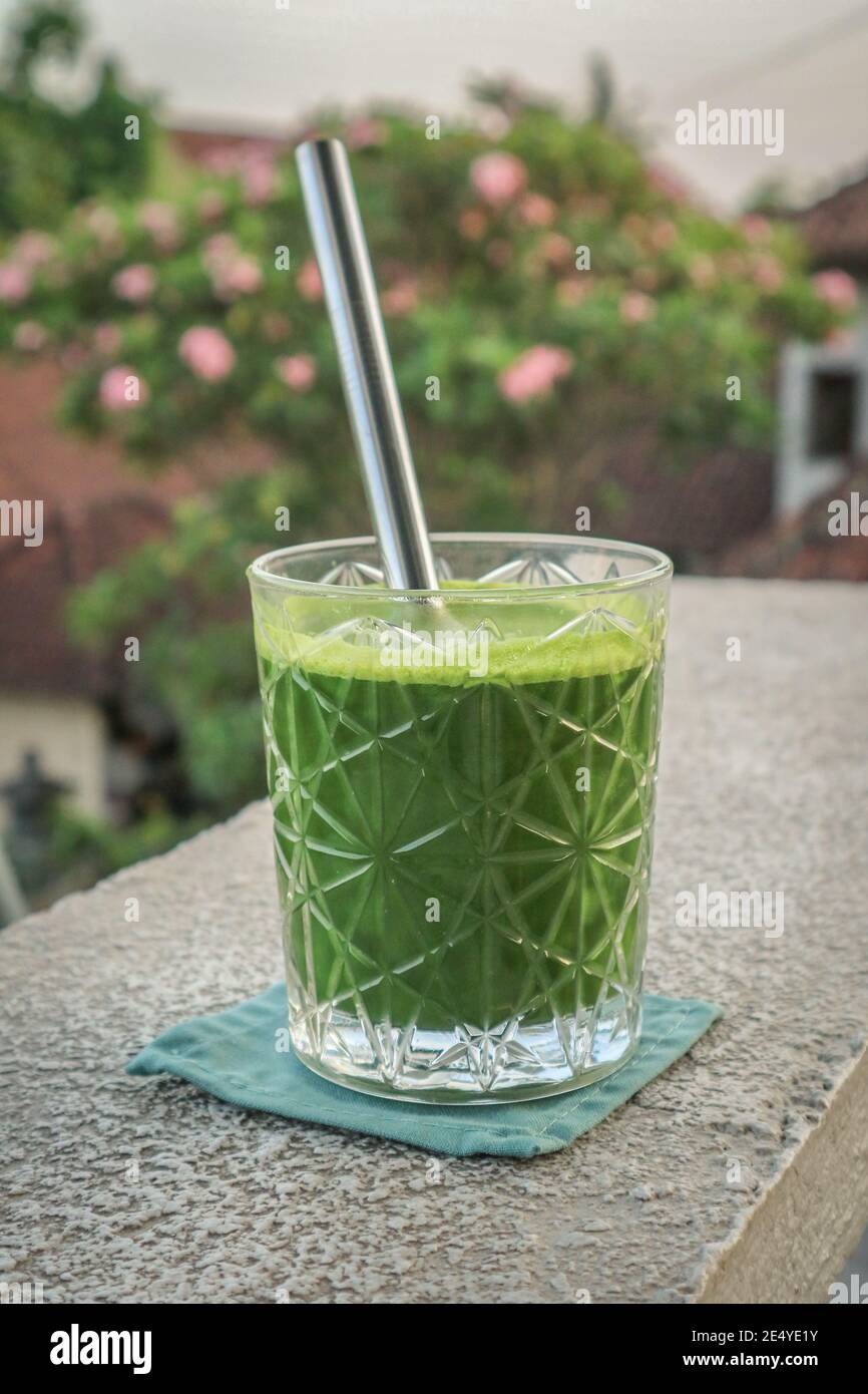 Glas grüner Smoothie mit Trinkhalmen aus Metall in Nahaufnahme Stockfoto