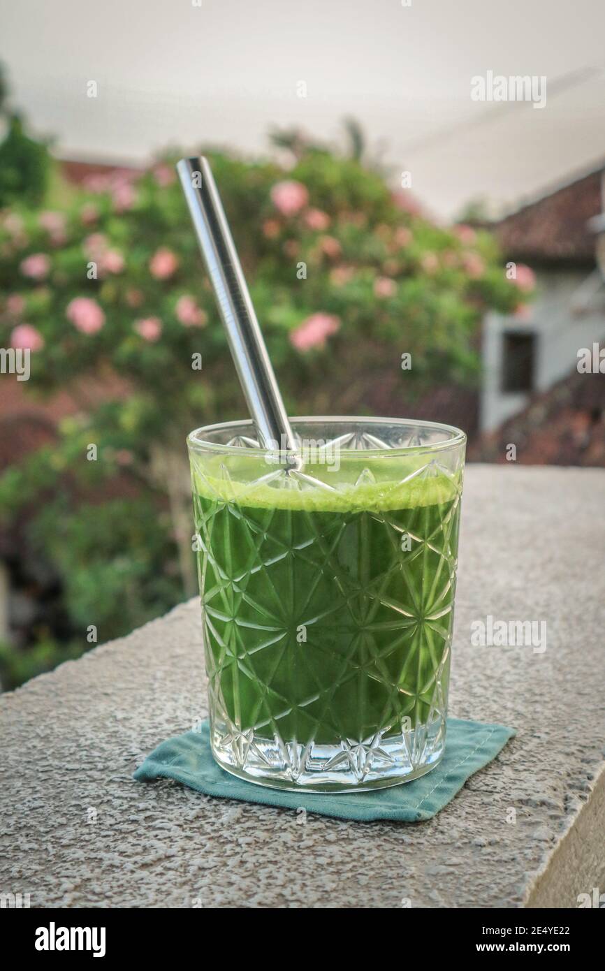 Glas grüner Smoothie mit Trinkhalmen aus Metall in Nahaufnahme Stockfoto