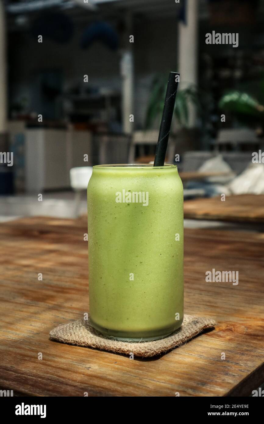 Glas grüner Smoothie mit Trinkhalm aus der Nähe Stockfoto