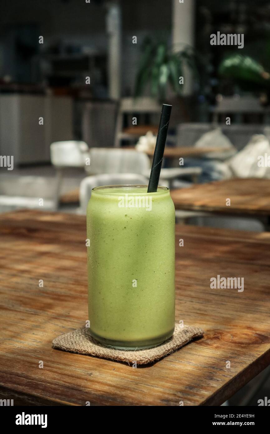 Glas grüner Smoothie mit Trinkhalm aus der Nähe Stockfoto