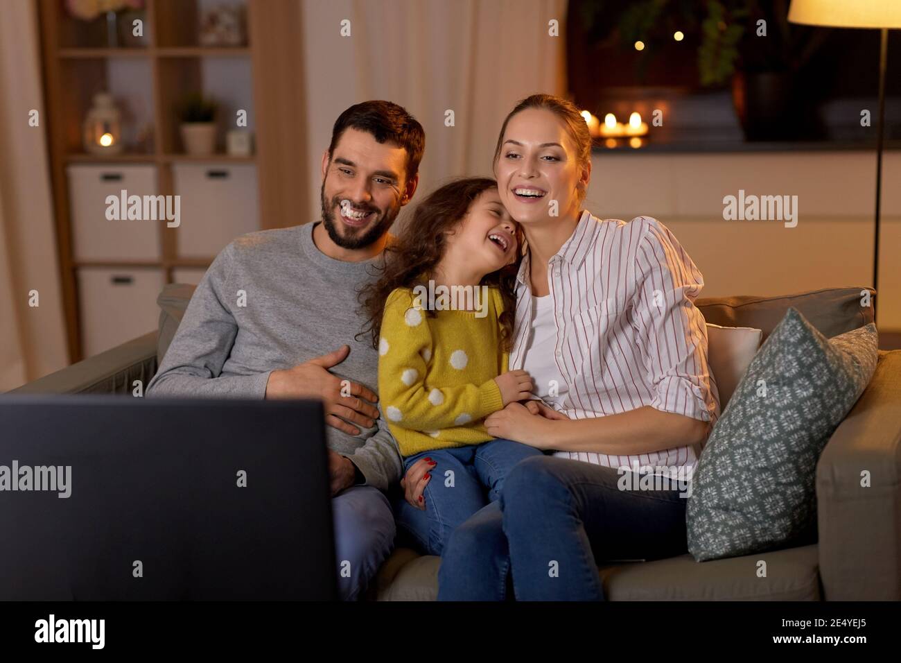 Glückliche Familie, die nachts zu Hause fernsehen sieht Stockfoto