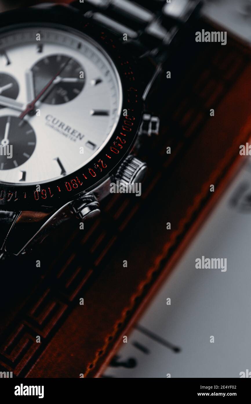 10. VON RAMADAN, ÄGYPTEN - 04. Jan 2021: Eine Nahaufnahme der Seitennadel einer silbernen Uhr auf braunem Leder-Portemonnaie auf weißer Note Stockfoto