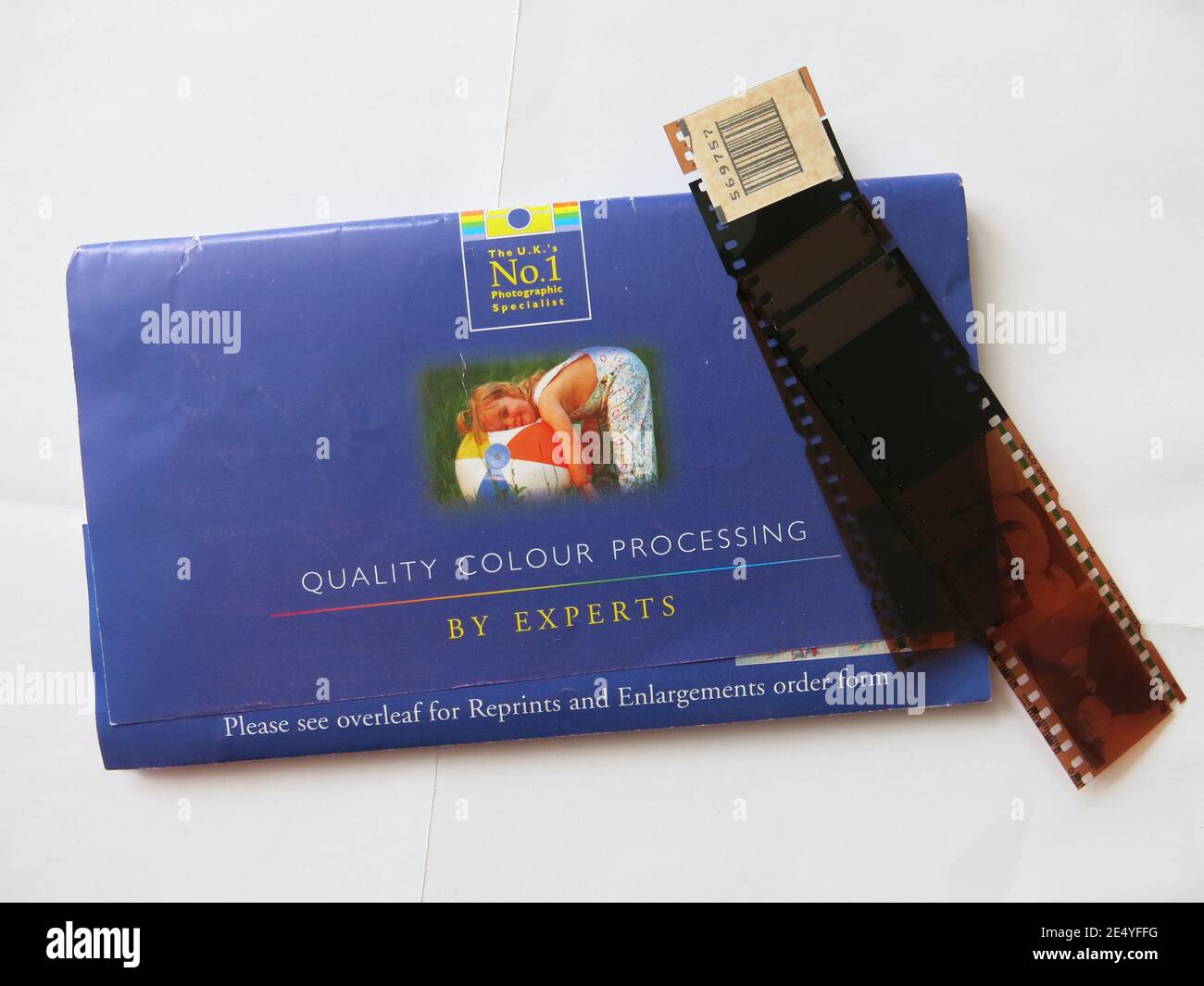 Ein Streifen von Negativen auf der blauen Brieftasche von Foto-Spezialisten, Jessop, für die hochwertige Farbverarbeitung von Pre-Digital-Kamera-Filme. Stockfoto