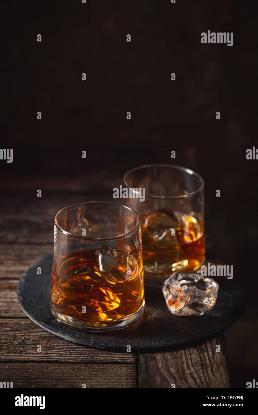 Zwei Gläser des Whiskys mit Eis isoliert auf einem Dunkler Hintergrund Stockfoto