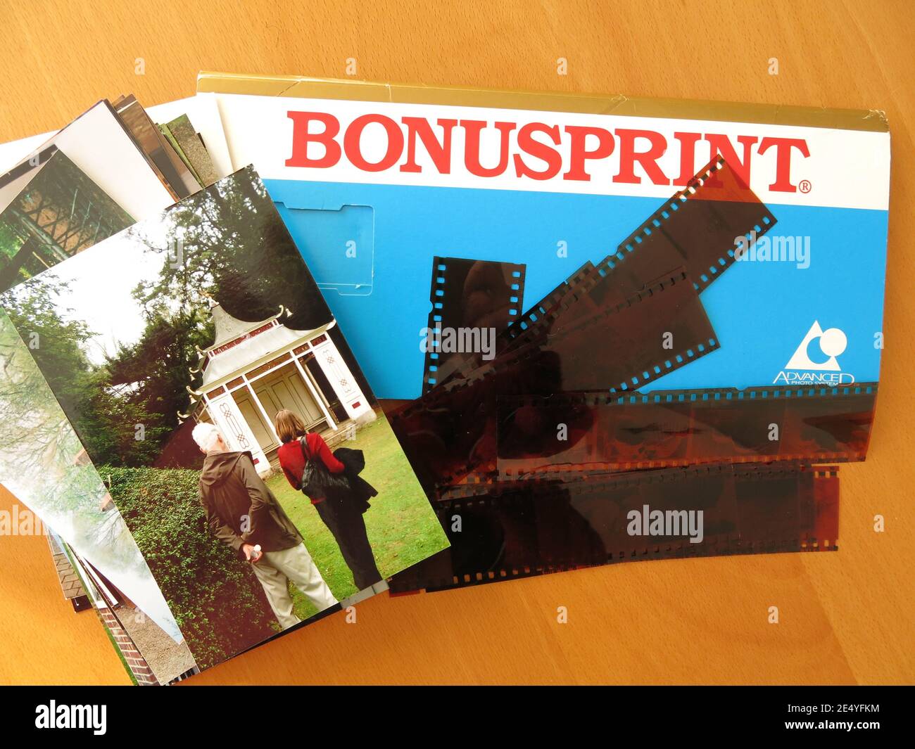 Ein Stapel gedruckter Fotos, die Negative und eine blaue Bonusprint Display-Brieftasche, wie sie vor der Digitalkamera-Technologie an Kunden verschickt wurde. Stockfoto