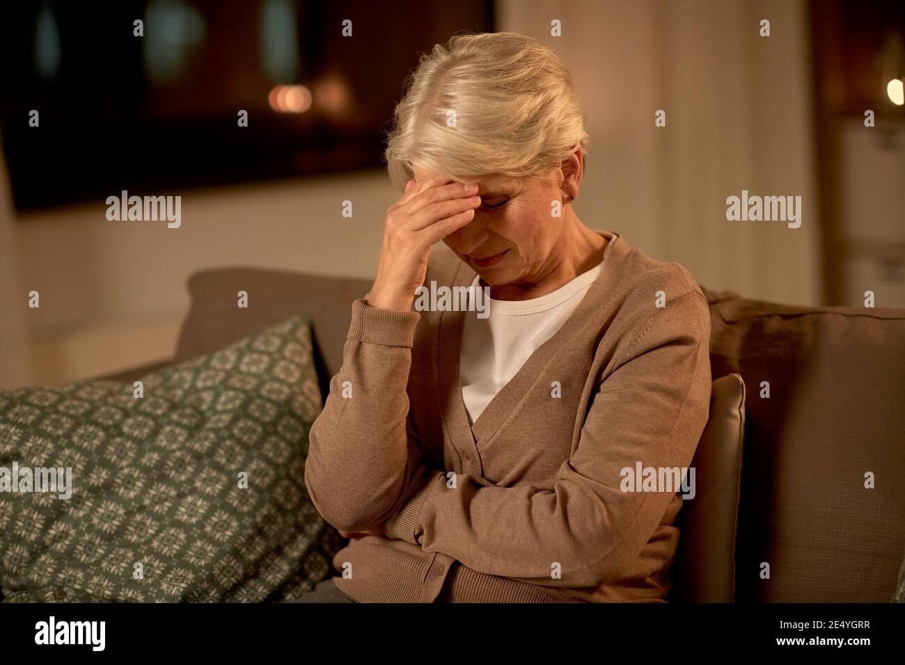 Unglückliche ältere Frau, die an Kopfschmerzen leidet Stockfoto