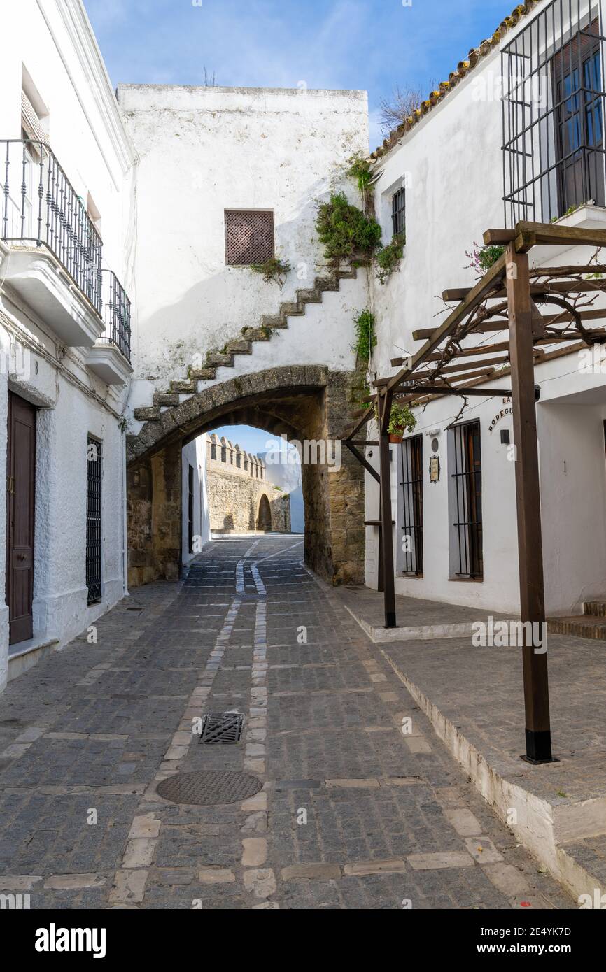 Vejer de la Frontera, Spanien - 17. Januar 2021: Enge Straße und altes Stadttor in Vejer de la Frontera Stockfoto