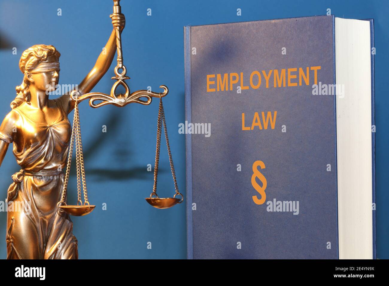 Symbolbild: Nachschlagewerk Arbeitsrecht und Justitia Stockfoto