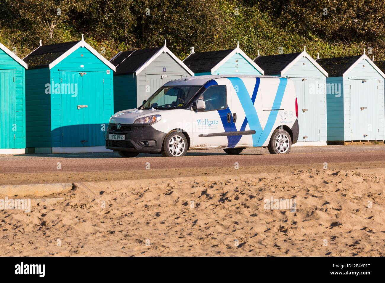 Wallgate robuste, innovative Waschräume, die im Januar eine lange Promenade an Strandhütten in Bournemouth, Dorset, Großbritannien, vorbeifahren Stockfoto