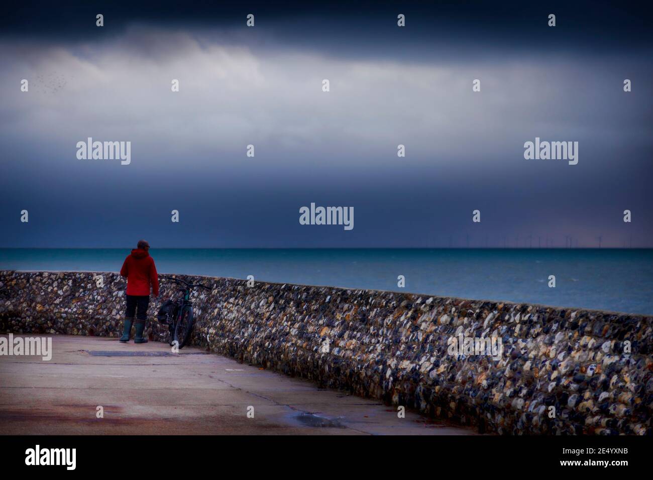 Mann, der das Meer bei Brighton groyne beobachtet Stockfoto