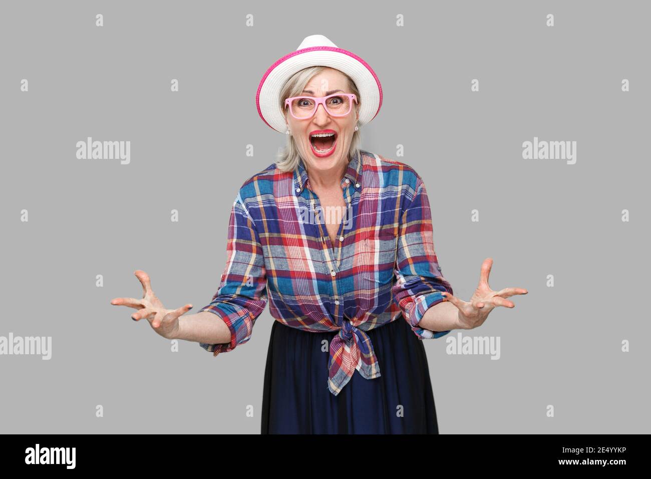 Was wollen Sie von mir? Portrait von Angry moderne, elegante, reife Frau im lässigen Stil mit Hut und Brille stehend, mit Blick auf die Kamera und Fragen Stockfoto