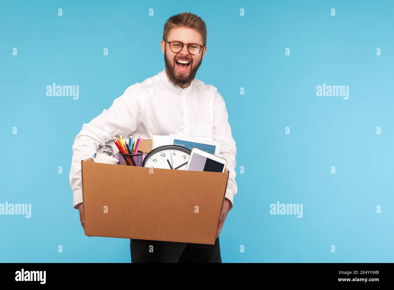 Extrem glücklicher Mann mit Bart in Brillen und weißem Hemd lächelnd hält großen Karton mit seinem Zeug, immer neue Arbeit oder Arbeitsförderung. Indoo Stockfoto