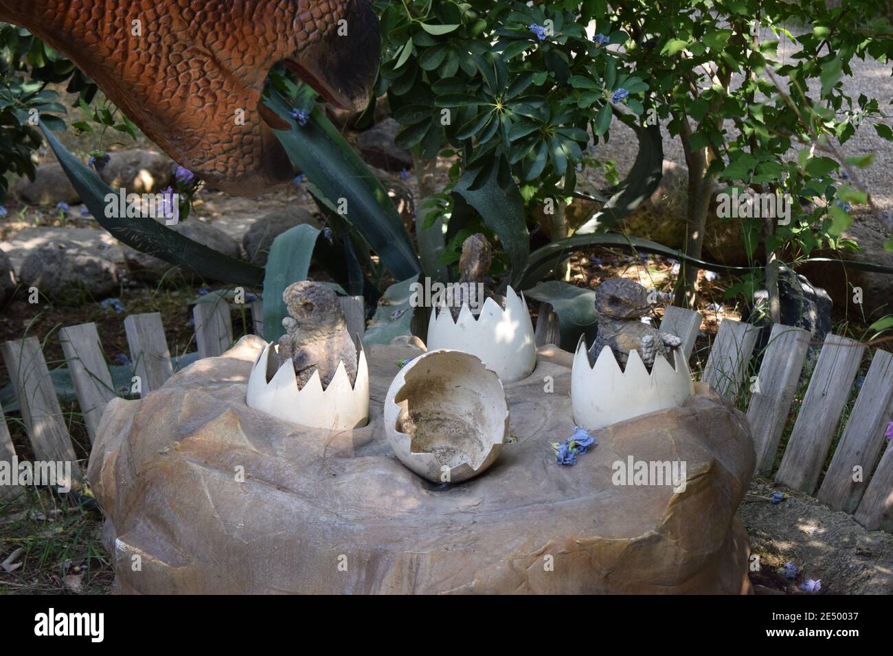 Dinosaurier-Statue im Waldpark in der Natur für Hintergrund. Realistisches Modell des Dinosauriers in der Nähe seines Nestes mit Eiern. Dinopark in der Türkei, Goynuk. Dinosaurier Stockfoto