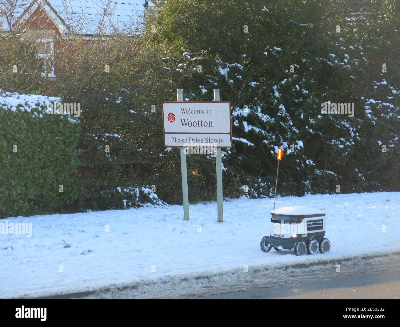 Schnee auf den Gehwegen hält den 6-rädrigen Raumschiff-Roboter nicht davon ab, Lebensmittel an die Bewohner in Wootton, Northampton, zu liefern; Januar 2021 Stockfoto