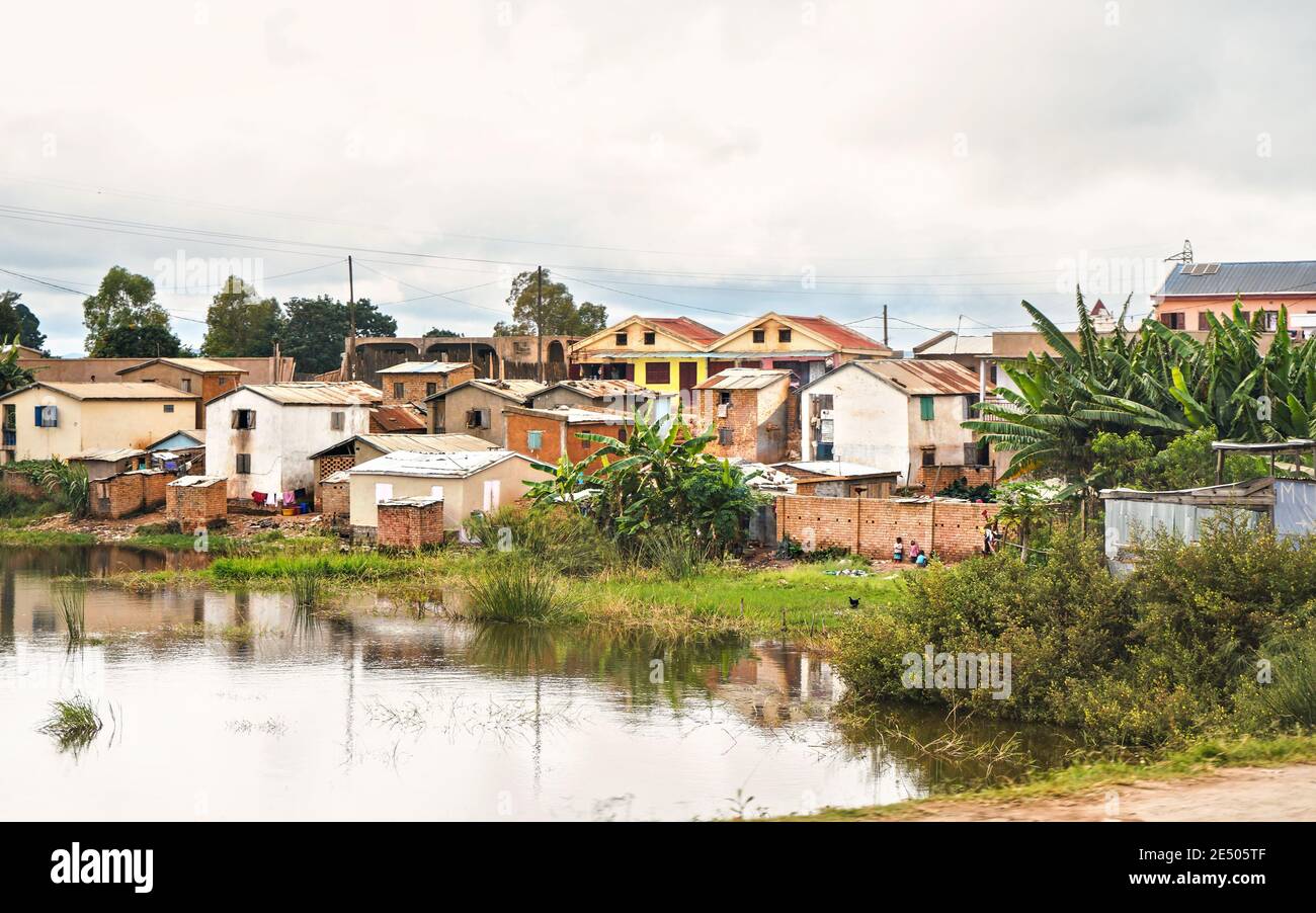 Antananarivo, Madagaskar - 24. April 2019: Gruppe von unbekannten madagassischen Kindern, die vor ihrem Haus stehen, Gras und überschwemmten Reisfeldern Foregrou Stockfoto