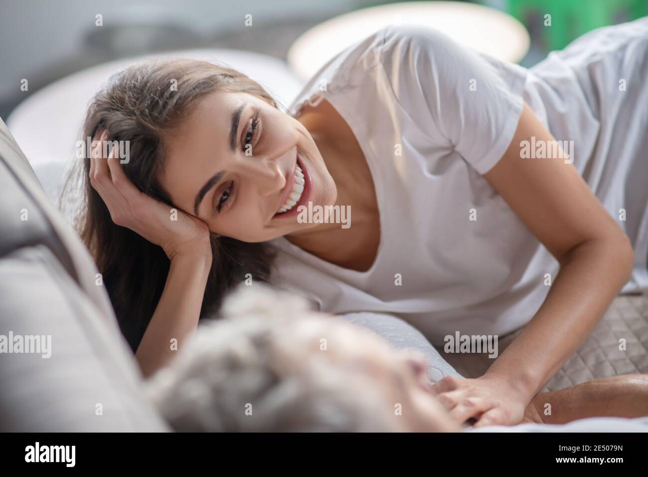 Frau, die mit einem Mann spricht, während sie im Bett bleibt Stockfoto