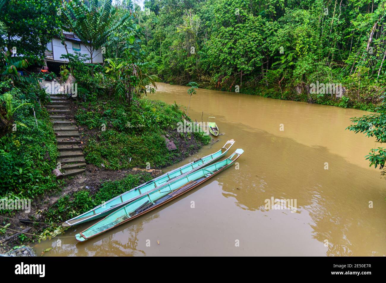 Hölzerne Langboote ruhen in der Nähe von IBAN-Häusern in Tanninwasser Stockfoto