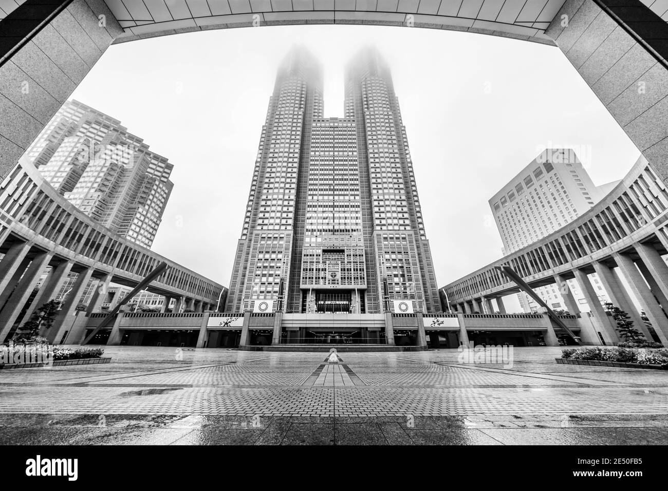 Schwarz-Weiß-symmetrische Aufnahme der Innenstadt von Tokio an einem nebligen Tag, mit zwei Wolkenkratzern im Zentrum Stockfoto