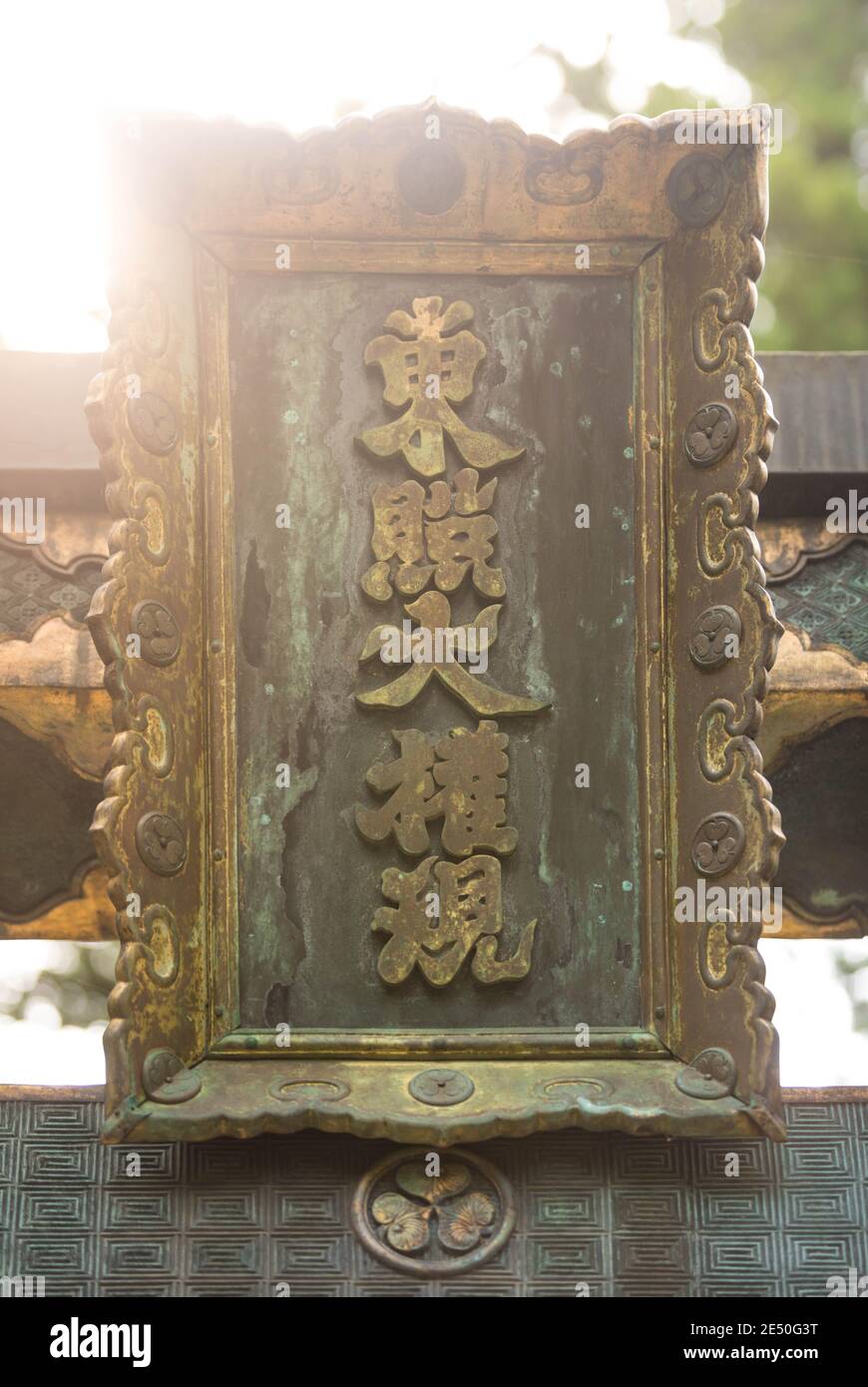 Nahaufnahme einer antiken japanischen Bronzeeinschrift überflutet Licht in einem shinto Tempel Stockfoto