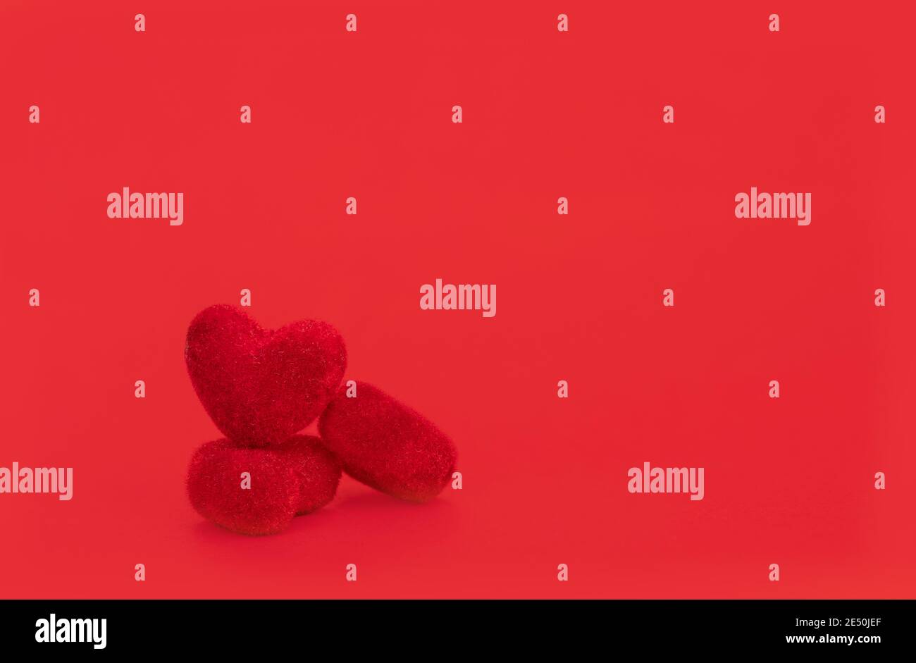 Nahaufnahme rote Herzen sind auf rotem Hintergrund platziert. Valentinstag-Konzept. Stockfoto