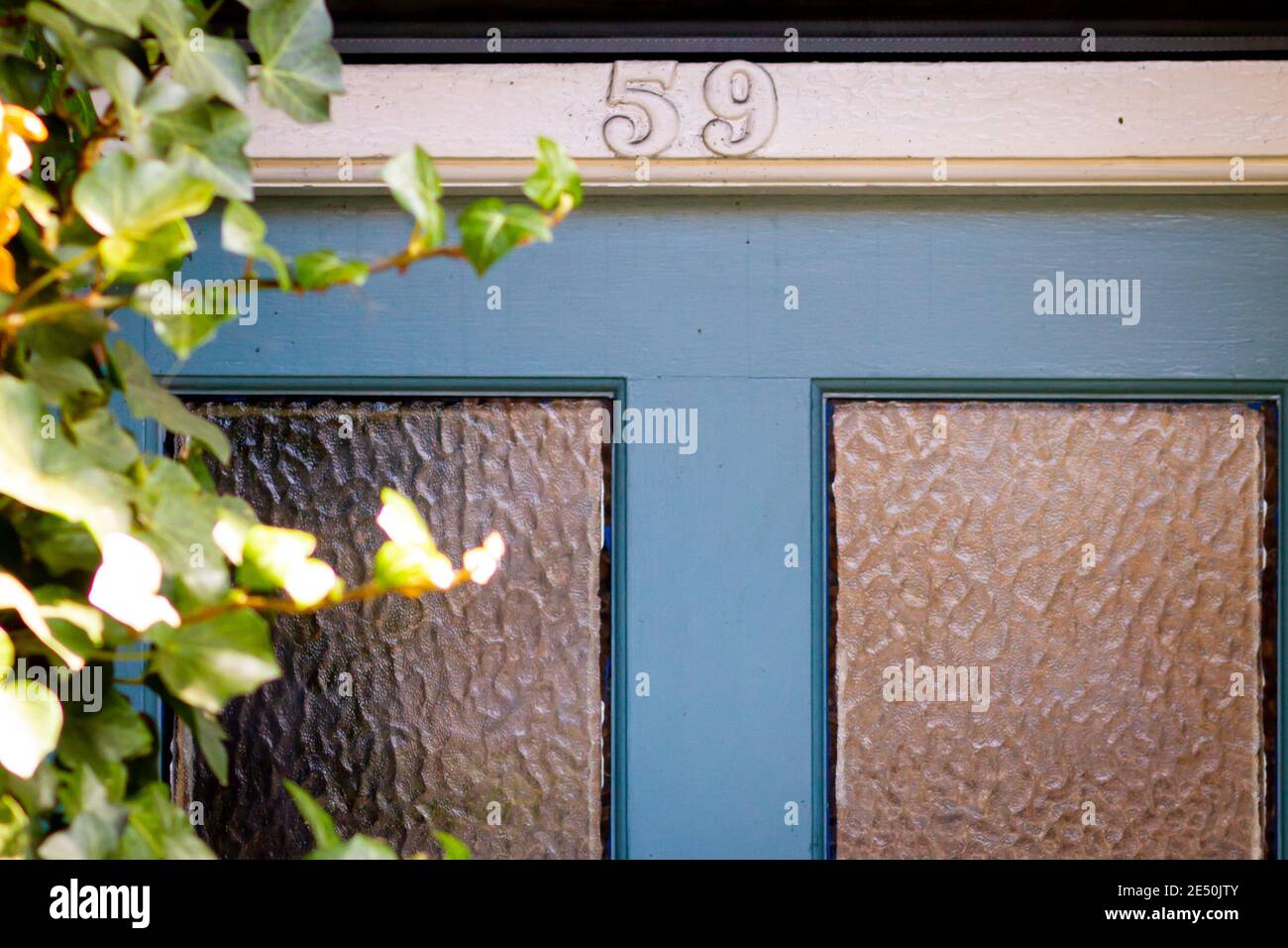 Nummer 59 auf einer alten hölzernen Eingangstür mit Glas Bedienfelder Stockfoto