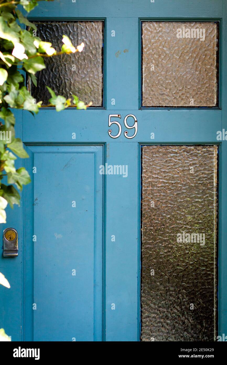 Nummer 59 auf einer alten hölzernen Eingangstür mit Glas Bedienfelder Stockfoto