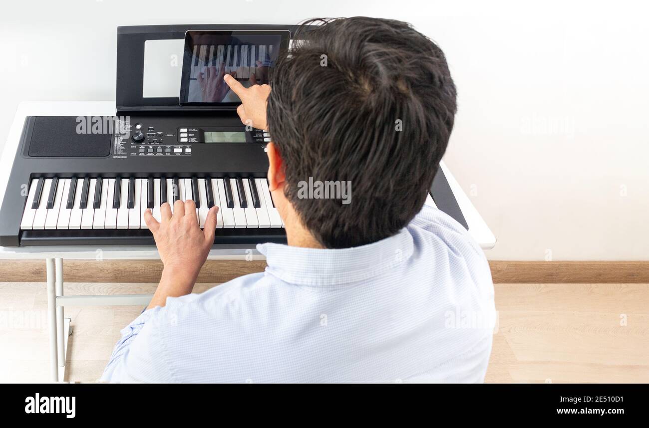 Klavier und Pianist, Klavier lernen mit App mit Tablet Stockfoto