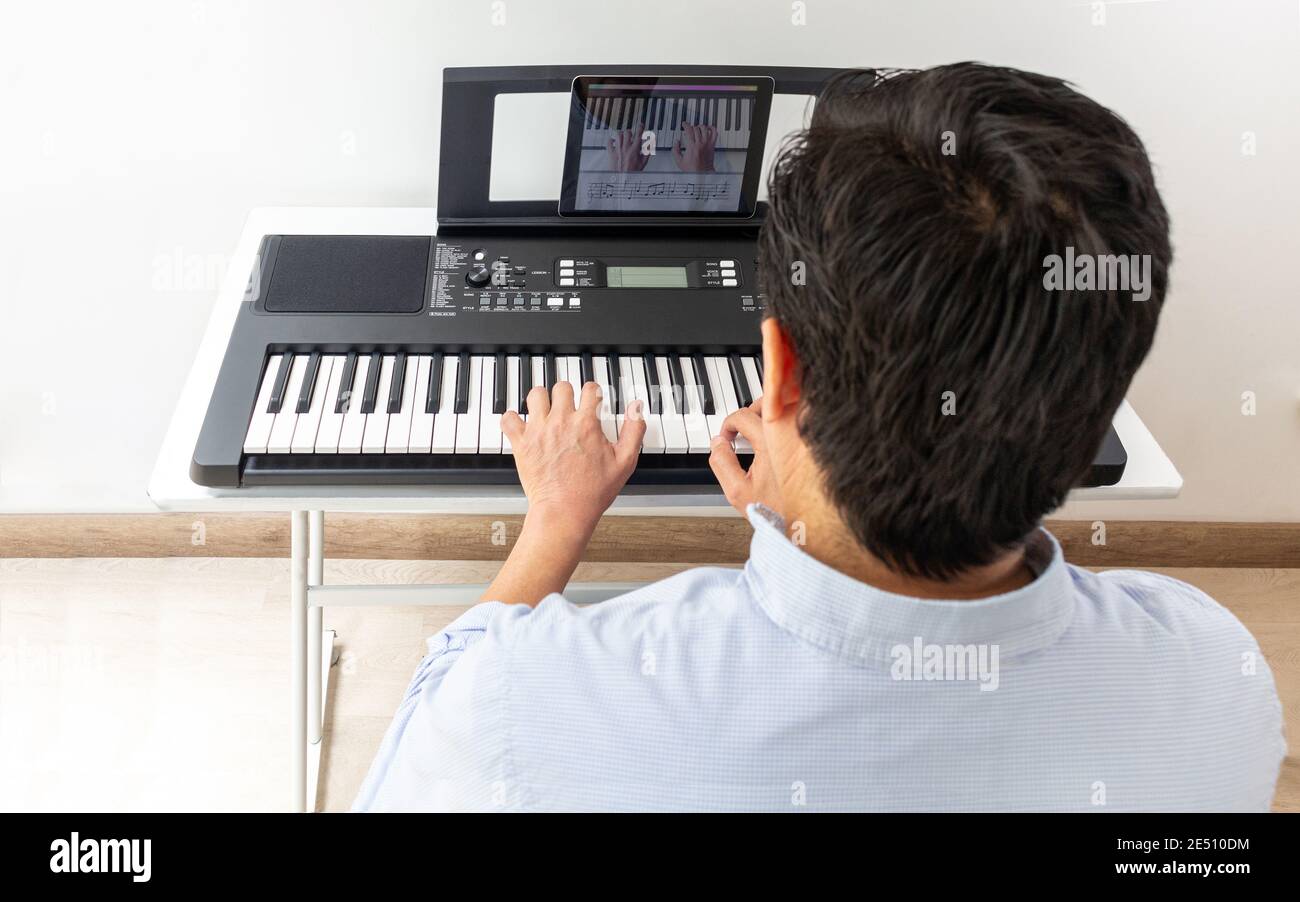 Klavier und Pianist, Klavier lernen mit App mit Tablet Stockfoto