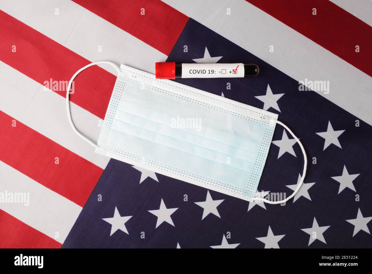 Medizinische Maske und Blutabnahmeröhrchen auf der usa-Flagge, Nahaufnahme, Draufsicht. Stockfoto