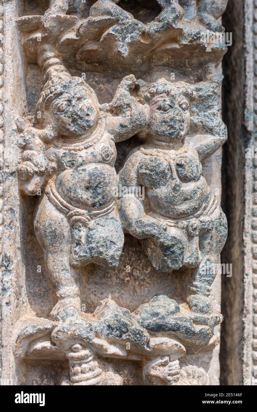 Lakkundi, Karnataka, Indien - 6. November 2013: Kasivisvesvara Tempel, Grauer Stein fehlende Beine tanzen Paar Skulptur an der Außenwand. Stockfoto