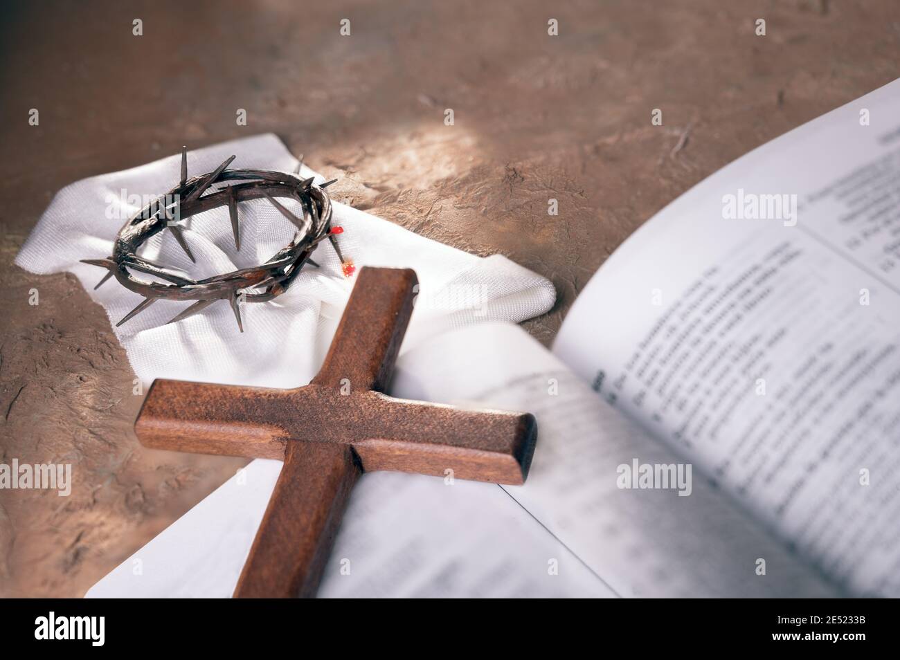 Dornenkrone und Holzkreuz über offenem bibelhintergrund mit Platz für die Inschrift. Christliches Osterkonzept. Stockfoto