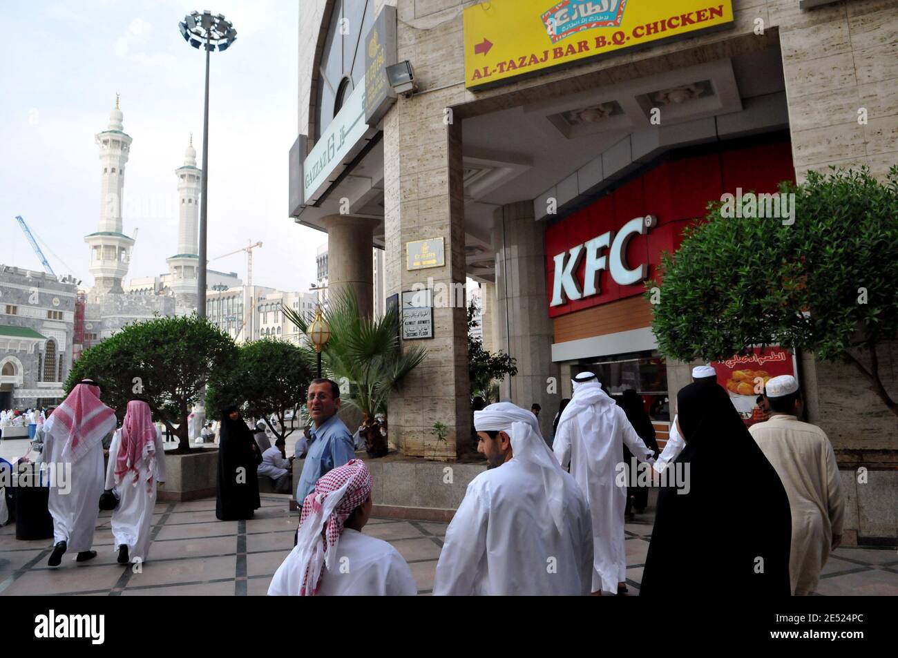 Pilger werden neben dem Fast-Food-Restaurant "KFC" (Kentucky Fried Chicken) in einem Einkaufszentrum mit Blick auf die große Moschee rund um die "kaaba", oder der "Cube", der Ort, an dem Hunderte von Millionen von Muslimen auf der ganzen Welt jeden Tag beten, in Mekka, Saudi-Arabien am 5. Juni 2008 gesehen. Foto von Ammar Abd Rabbo/ABACAPRESS.COM Stockfoto