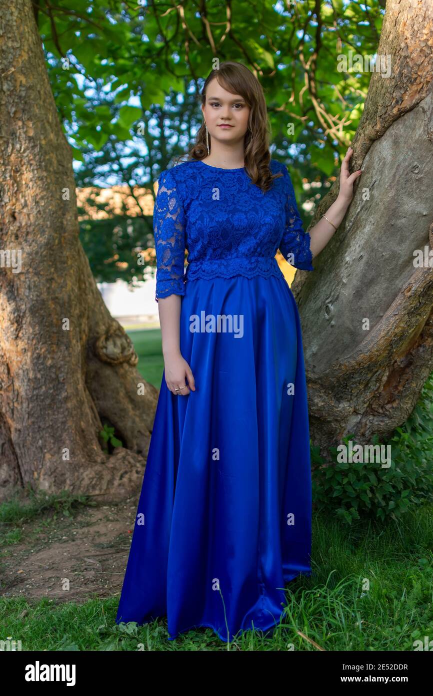 Porträt eines attraktiven Mädchen in der Natur nach dem Abitur. Schöne lächelnde weibliche Modell in eleganten Kleid posiert im Sommer Park Stockfoto