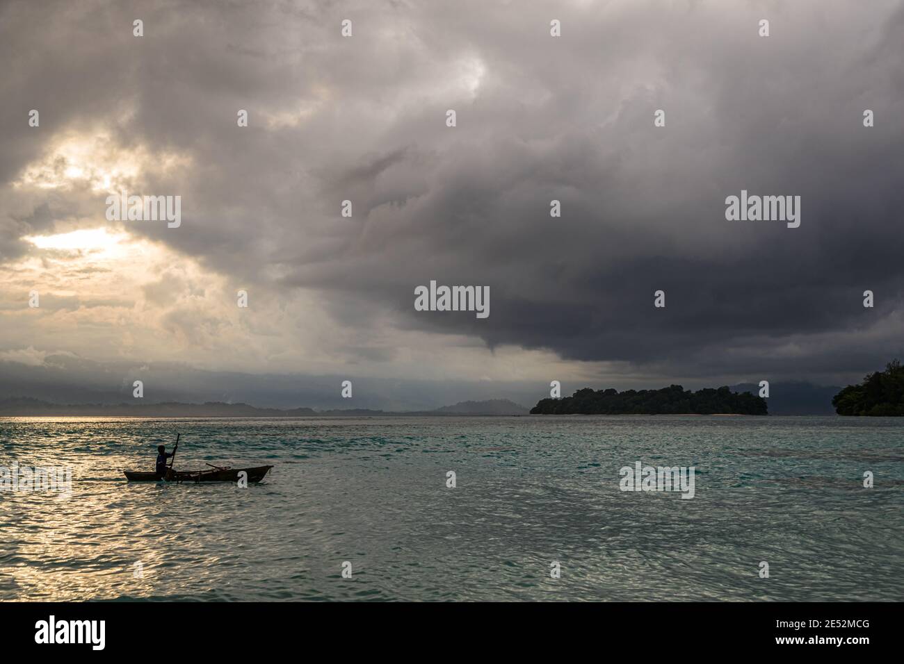 Junge Einheimische surft ein Outrigger-Kanu am Bougainville Strand, Papua-Neuguinea Stockfoto