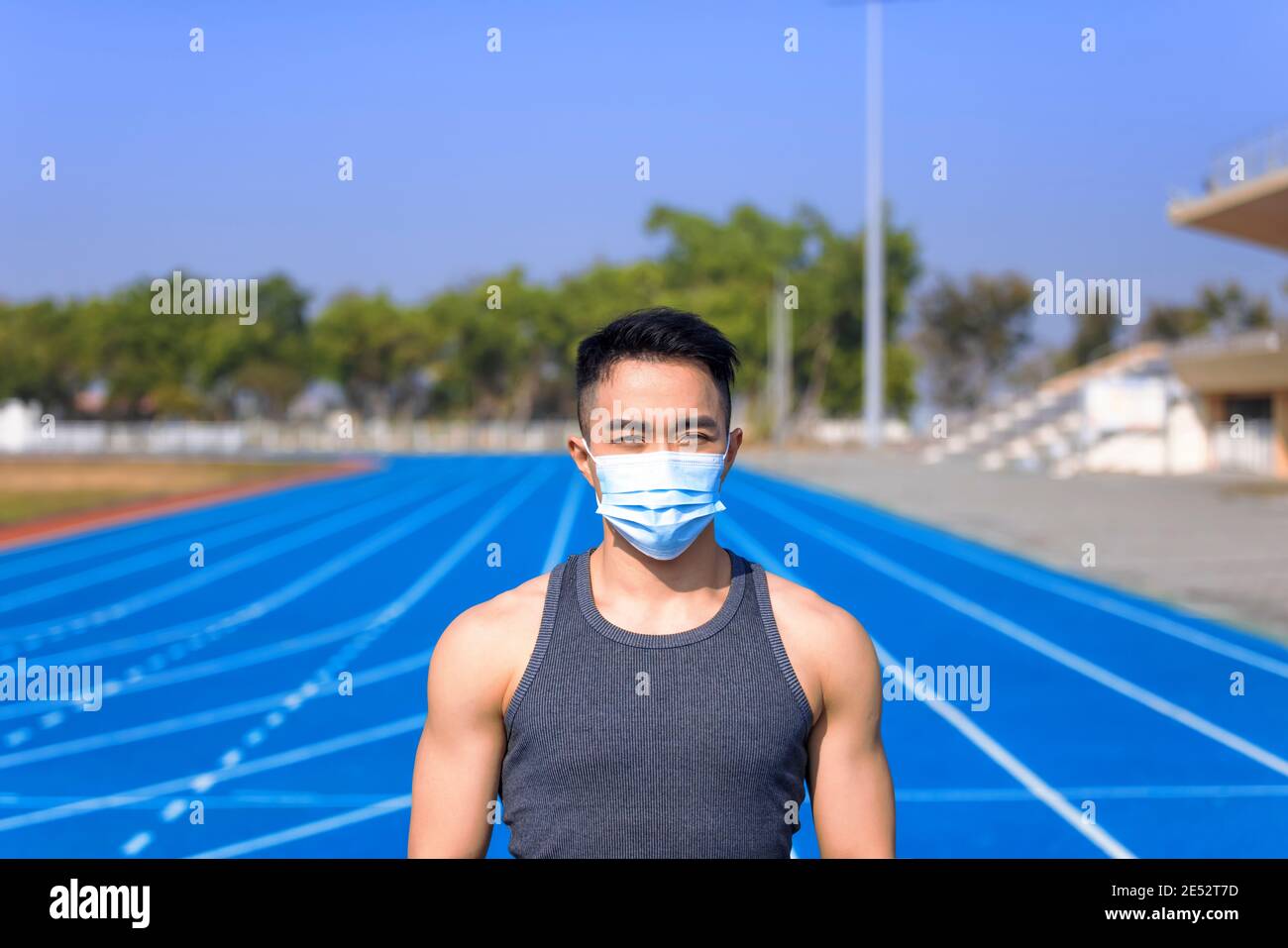 Mann in medizinischer Maske, der auf der Strecke steht und bereit ist Laufen Stockfoto