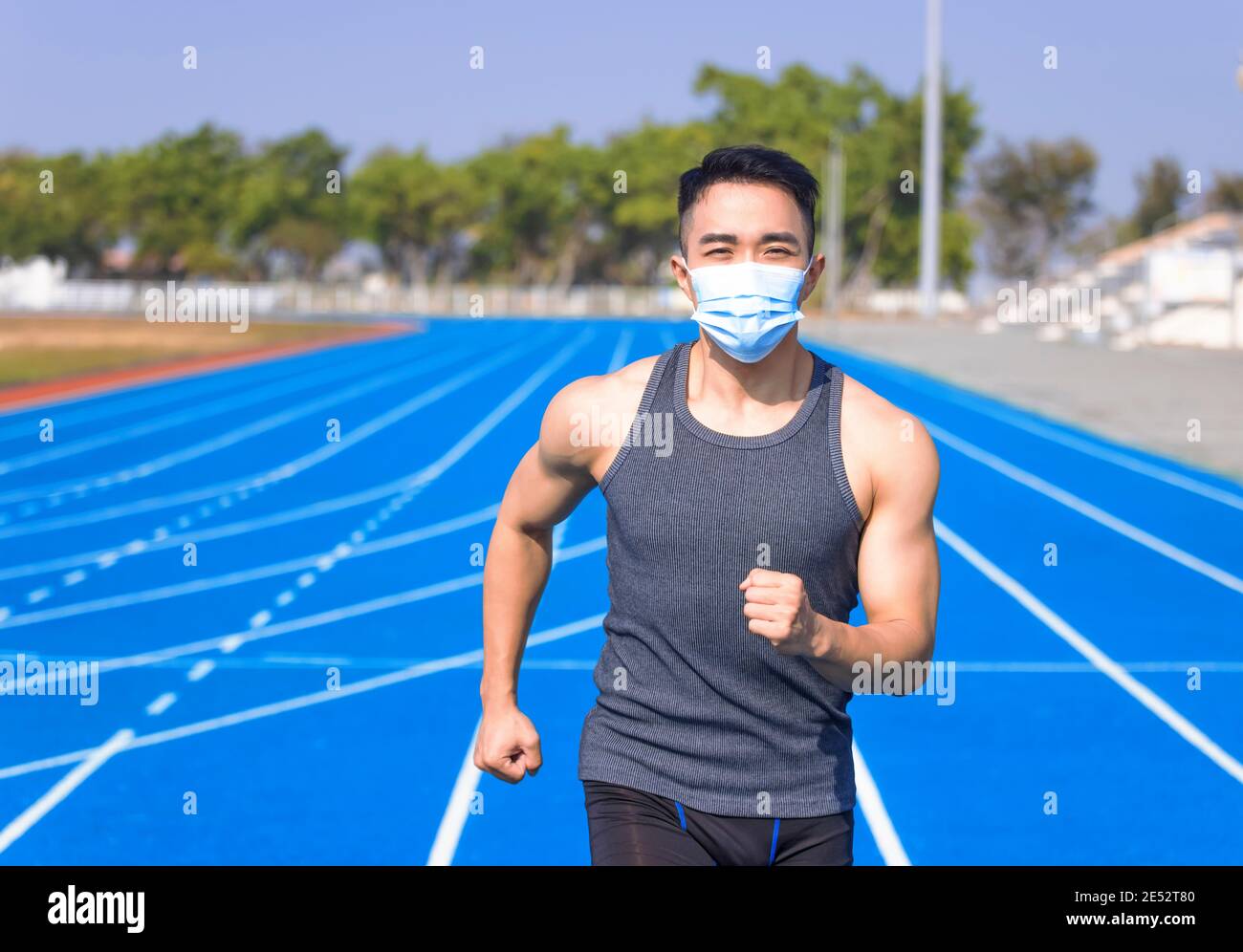 Mann in medizinischer Maske und läuft auf der Strecke Stockfoto