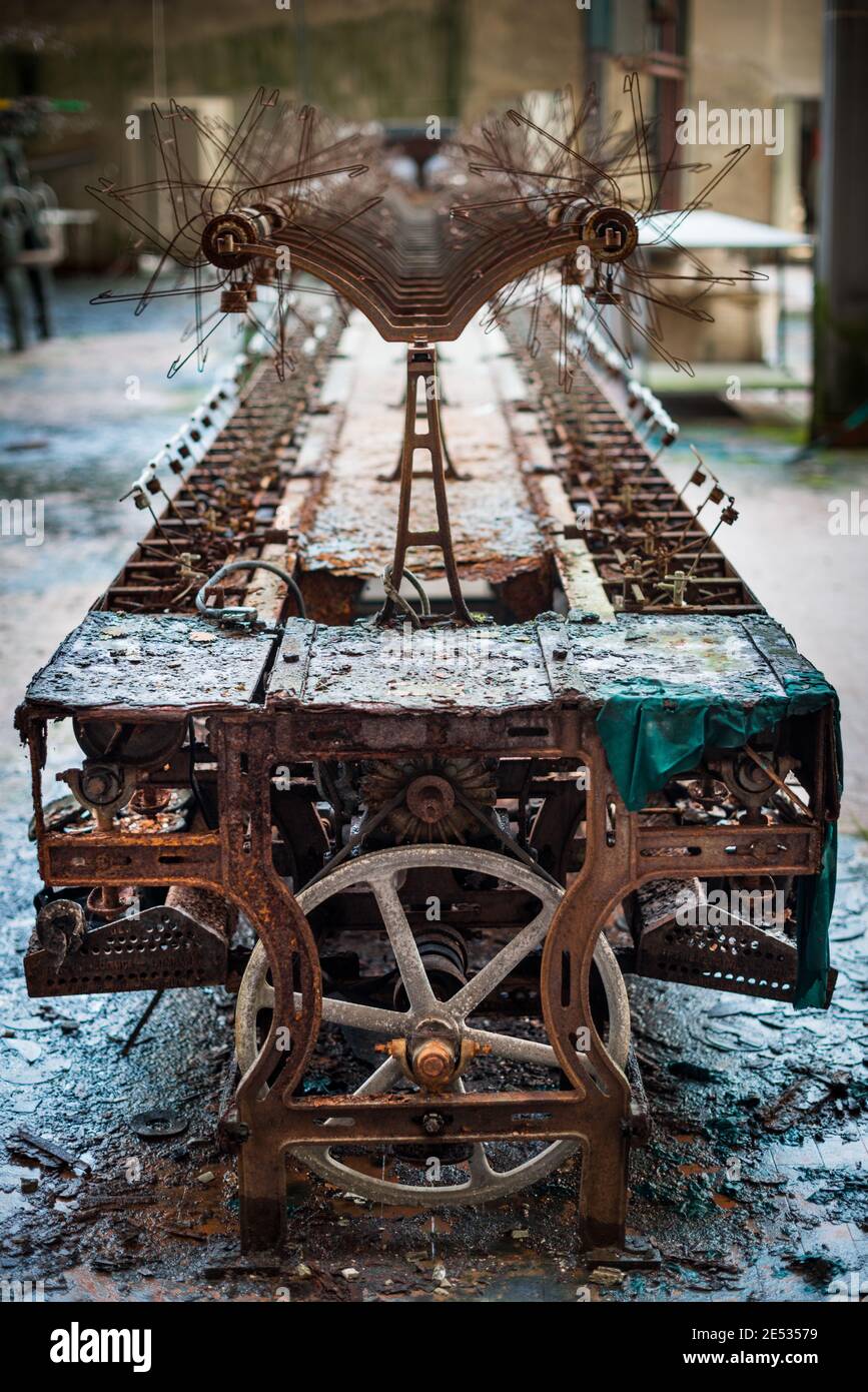 Symmetrische Nahaufnahme ein alter und rostiger Webstuhl in und Alte und verlassene italienische Textilfabrik Stockfoto