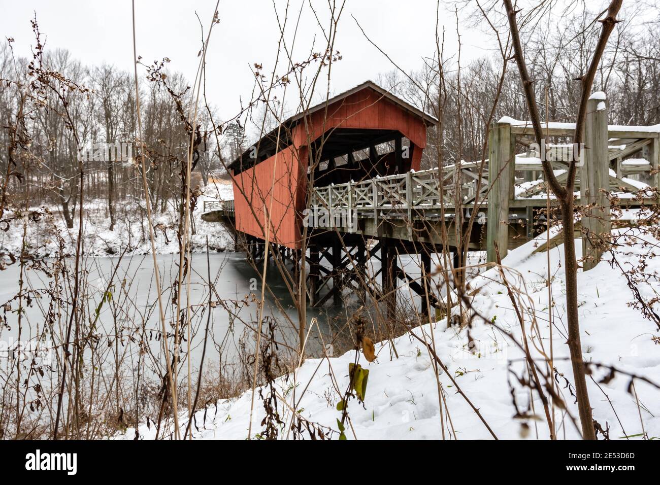 St. Clairsville, Ohio/USA - 15. Januar 2019: Schneebedeckte, historische Shaeffer Campbell Covered Bridge als Schuss durch das Unkraut und prahlte über das Verbot Stockfoto