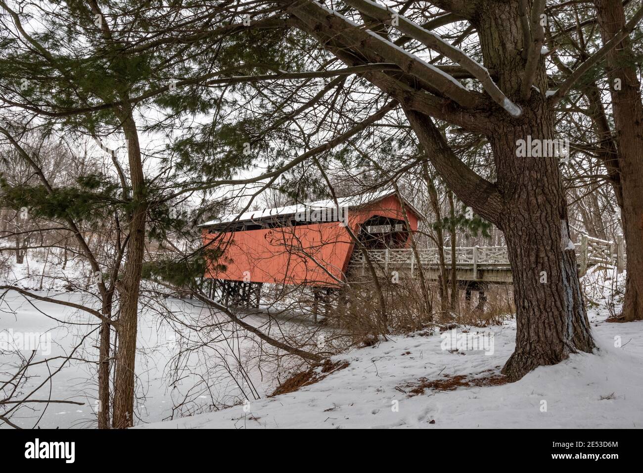 St. Clairsville, Ohio/USA- 15. Januar 2019: Schneebedeckte, historische Shaeffer Campbell Covered Bridge und der gefrorene College Pond aus der Sicht Stockfoto