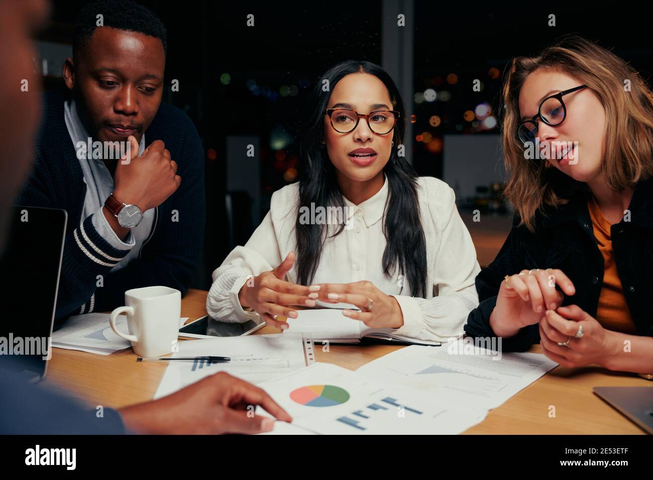 Junge Gruppe von multi ethnischen Business-Team Analyse von Finanzdokumenten Miteinander in der Nacht vor einer Frist Stockfoto