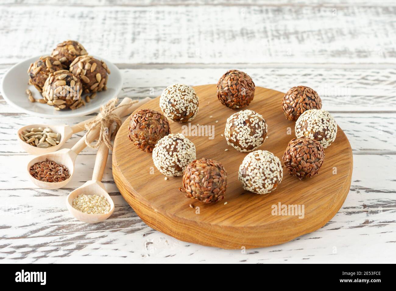 Gesunde rohe Energie Bälle. Süßigkeiten vegane Datteln, Kokosnusspulpe, Nüsse auf einem Holzschreibtisch. Konzept der nützlichen hausgemachten keine Zucker Bonbons. Stockfoto