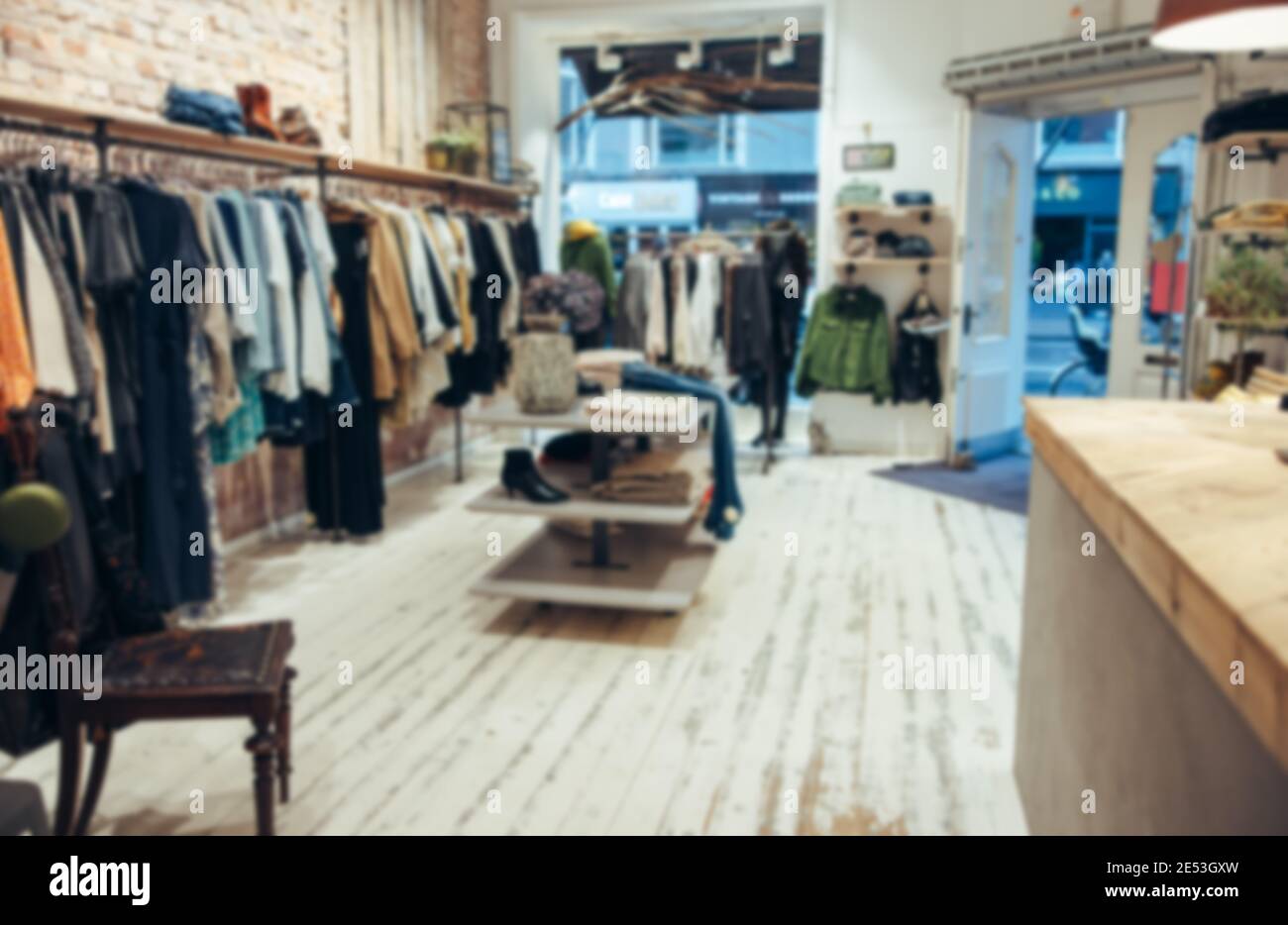 Verschwommene Aufnahme eines Modehaus. Das Innere eines kleinen Bekleidungsladens ohne Menschen. Stockfoto