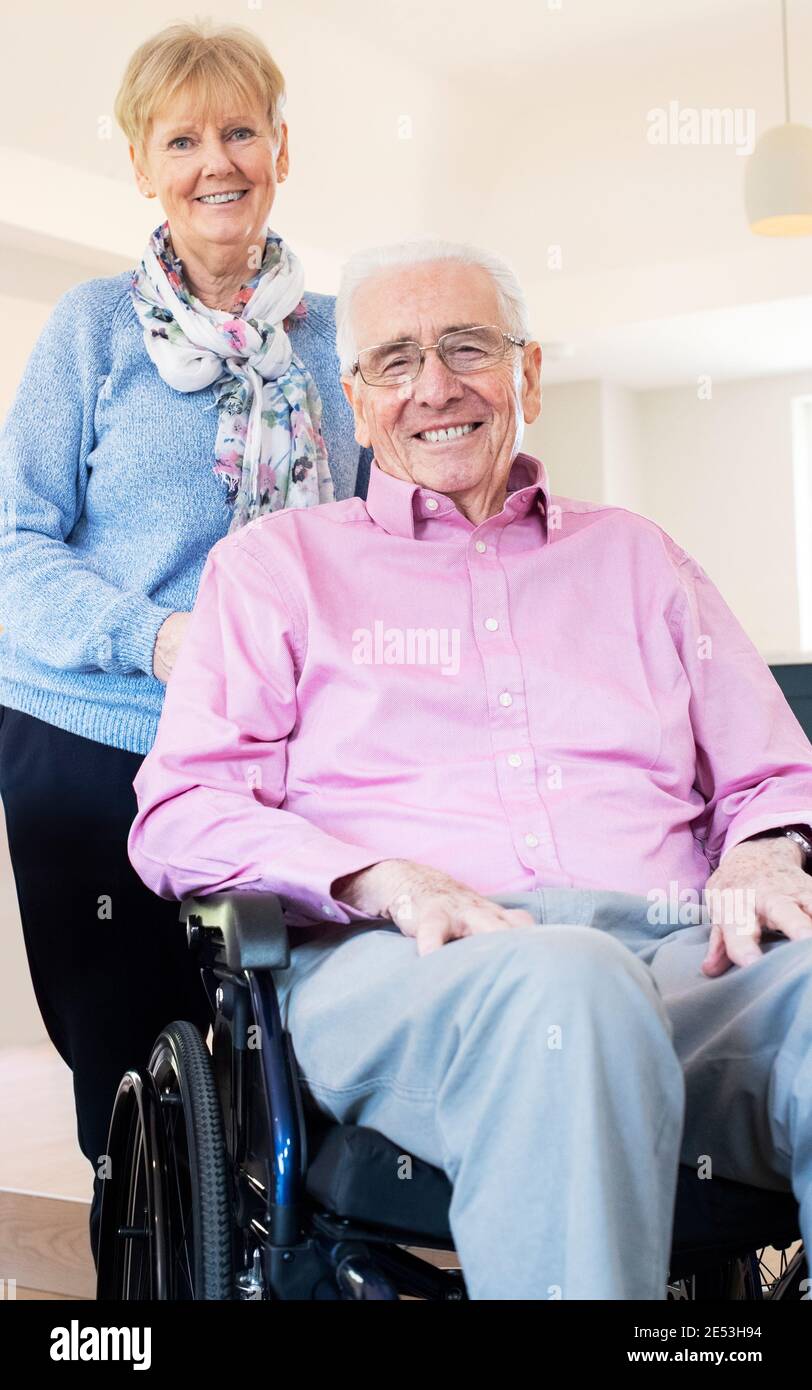 Porträt Eines Älteren Ehepaares Mit Ehemann Im Rollstuhl Zu Hause Stockfoto