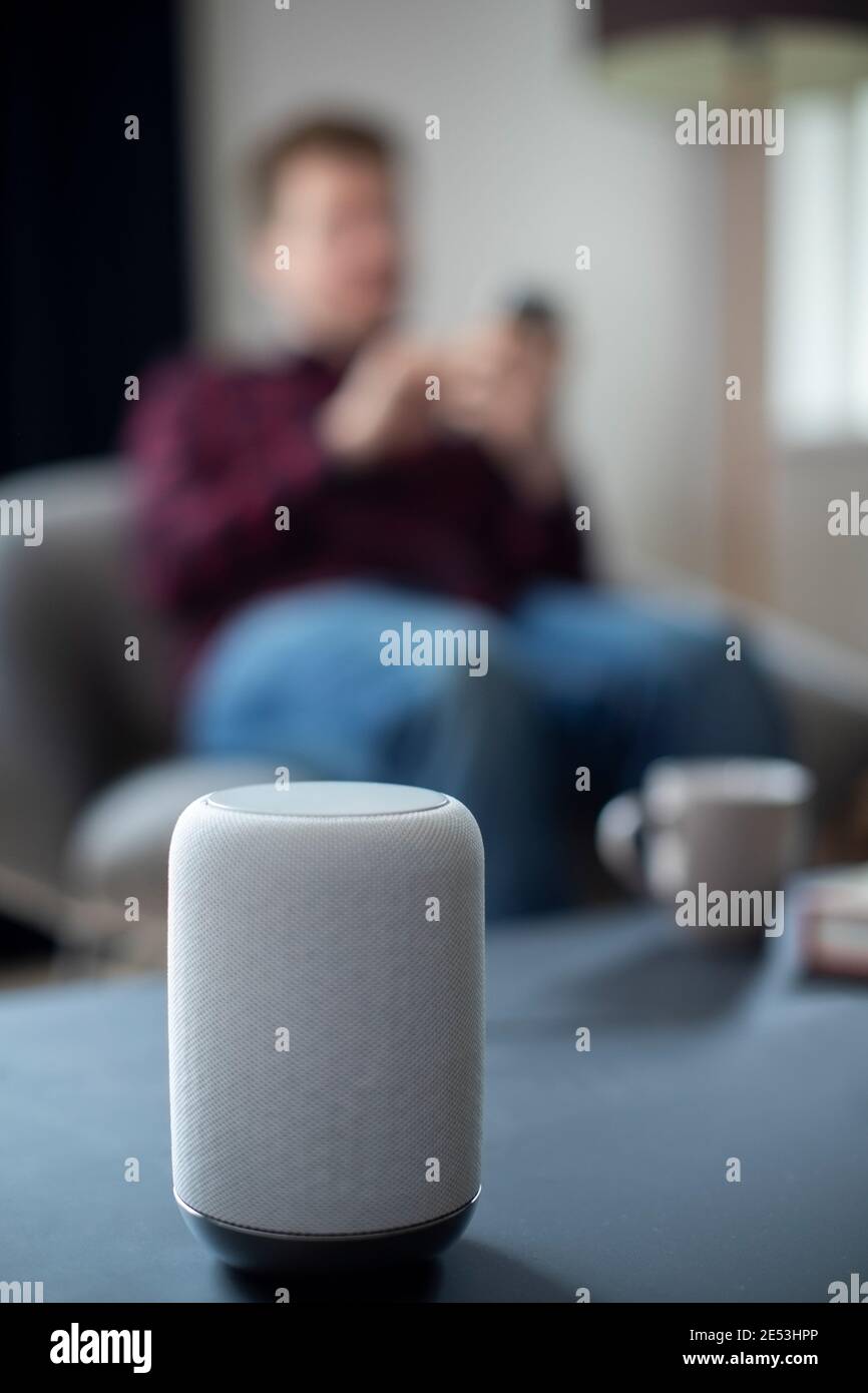 Man Streamen Musik Oder Podcast Auf Smart Speaker Von Mobil Telefon Zu Hause Stockfoto