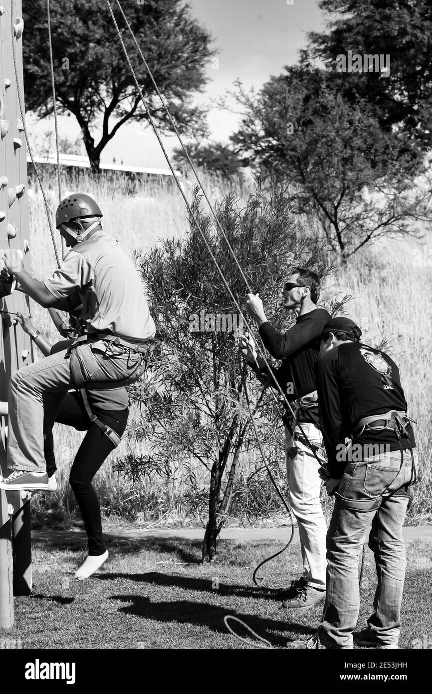 JOHANNESBURG, SÜDAFRIKA - 06. Jan 2021: Johannesburg, Südafrika - 8. Juni 2012: Afrikanischer Mensch, der Spaß an einer Kletterwand im Freien hat Stockfoto