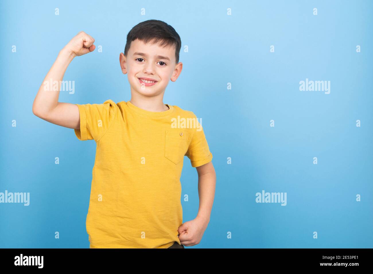 Portrait von niedlichen Jungen zeigt die Muskeln seines Arms. Power Boy Stockfoto