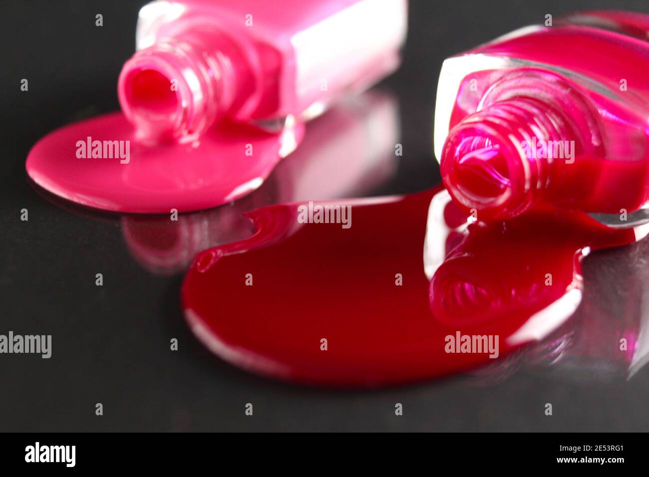 Beauty Hintergrund zwei Flaschen Nagellack-Flaschen rot oder burgunderrot pink Spill gegossen auf dem Tisch auf einem schwarzen Hintergrund mit einem Copyspace . Stockfoto